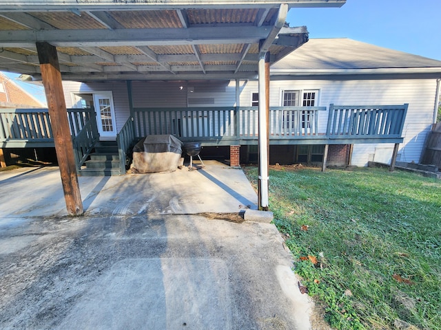 view of property exterior with a deck, a carport, and a lawn