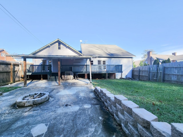 back of property featuring an outdoor fire pit and a wooden deck