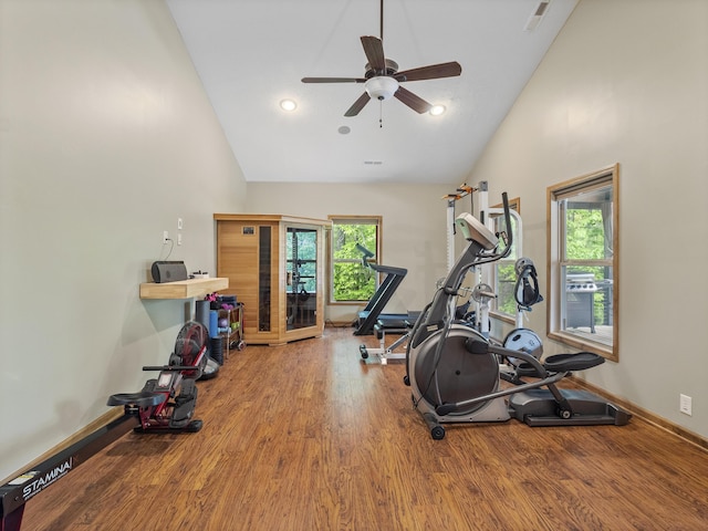 workout area featuring wood finished floors, ceiling fan, high vaulted ceiling, and baseboards