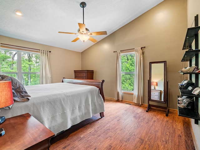 bedroom with lofted ceiling, wood finished floors, baseboards, and ceiling fan