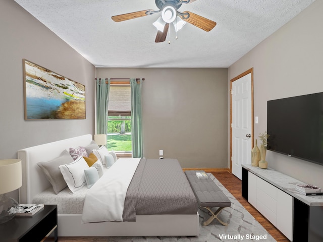 bedroom featuring a textured ceiling, wood finished floors, a ceiling fan, and baseboards