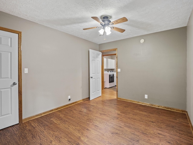 unfurnished room with washer / clothes dryer, light wood-type flooring, ceiling fan, a textured ceiling, and baseboards