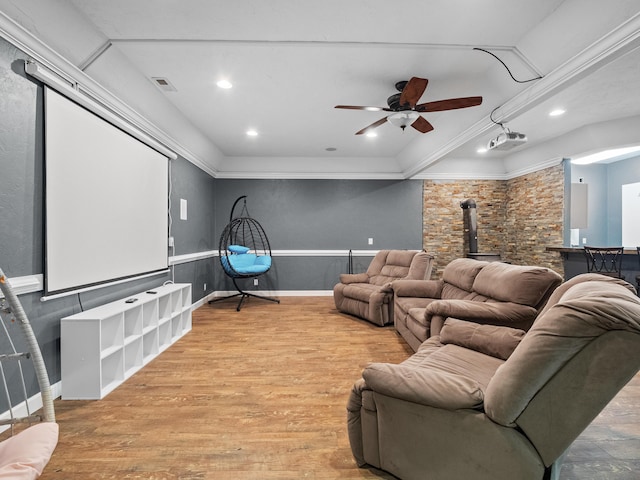 home theater with a wood stove, ceiling fan, light wood finished floors, crown molding, and recessed lighting