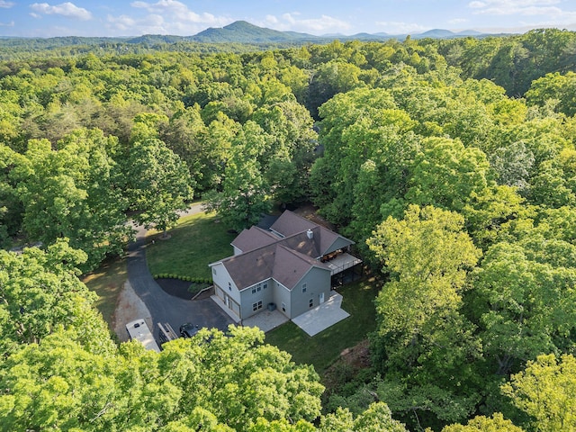view from above of property featuring a forest and a mountainous background