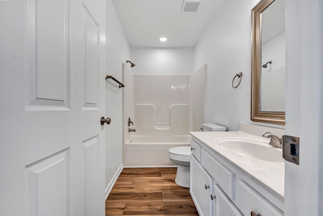 bathroom featuring toilet, wood finished floors, vanity, bathing tub / shower combination, and recessed lighting