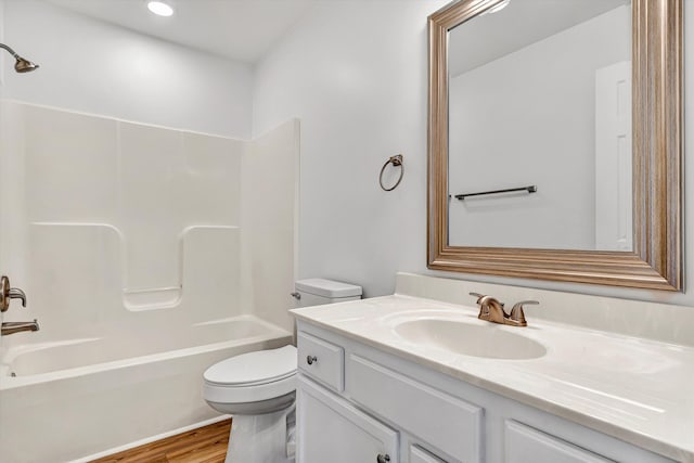 full bath featuring toilet, vanity, wood finished floors,  shower combination, and recessed lighting