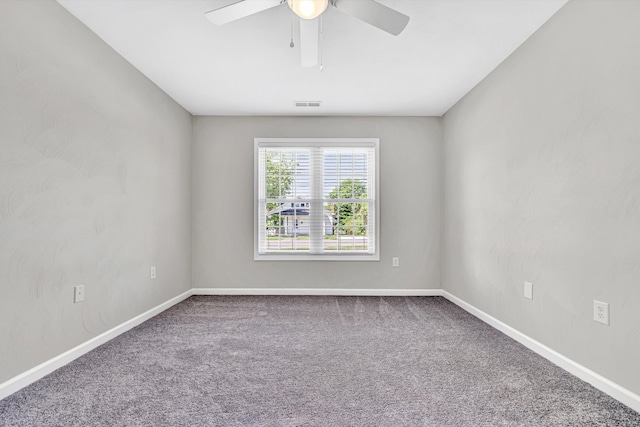 carpeted empty room featuring a ceiling fan and baseboards