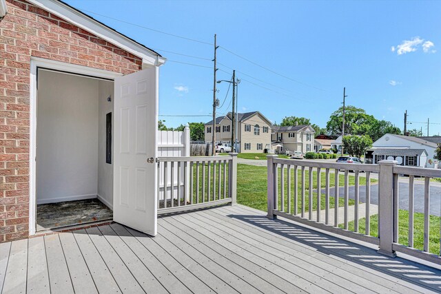 wooden deck with a residential view and a lawn