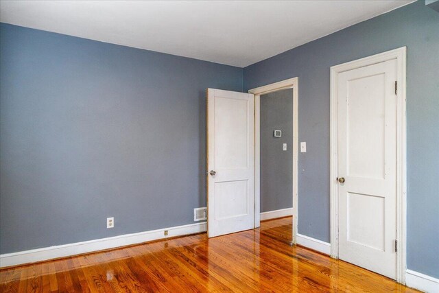 unfurnished bedroom with wood finished floors and baseboards
