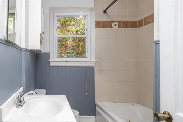 bathroom featuring a sink, toilet, and shower / bathtub combination