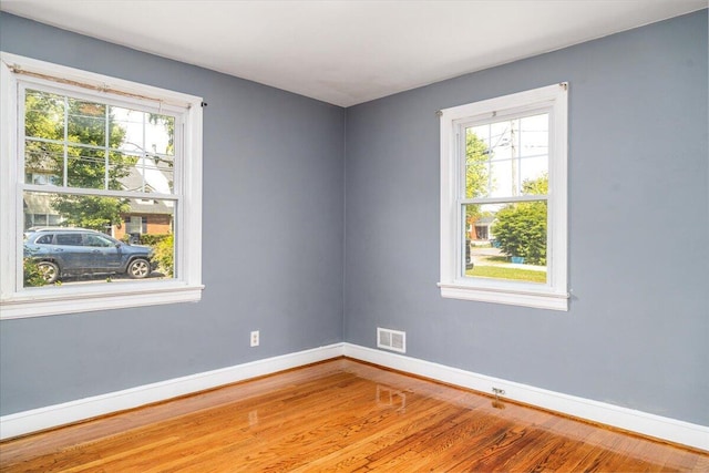 spare room with wood finished floors and baseboards