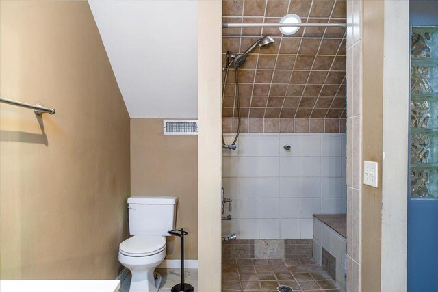 full bath with a stall shower, toilet, and lofted ceiling