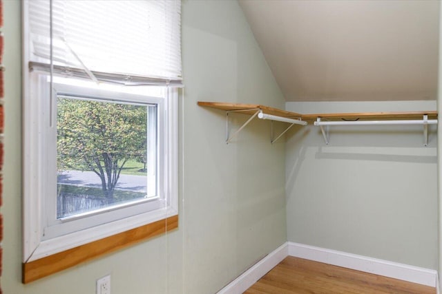 spacious closet featuring vaulted ceiling and wood finished floors