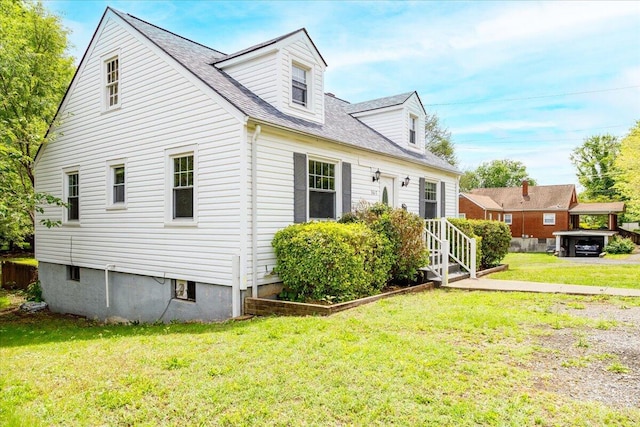 view of side of home with a yard, roof with shingles, and entry steps