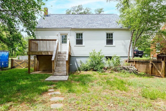 back of house with a wooden deck, a shingled roof, and a gate