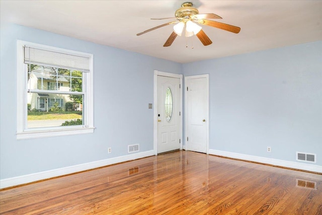 unfurnished room with baseboards, wood finished floors, and a ceiling fan
