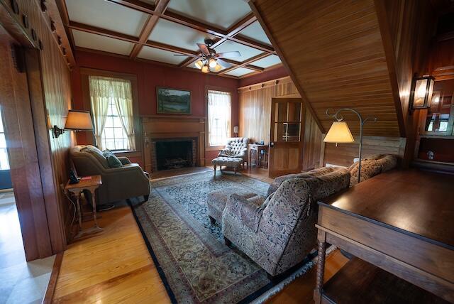 336 Turkey Run Ln, Rural Retreat, VA 24368 - living area with a fireplace with raised hearth, coffered ceiling, a ceiling fan, light wood-type flooring, and wooden walls