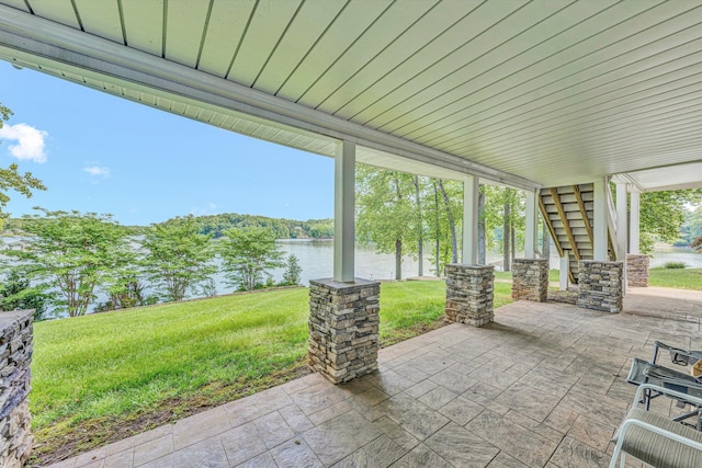 view of patio with stairs and a water view