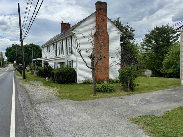 view of home's exterior with a chimney and a lawn