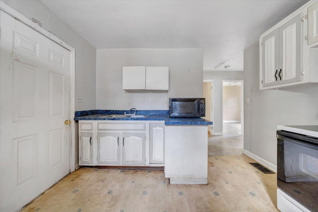 1919 Clinton Ave SE, Roanoke, VA 24013 - kitchen with range, black microwave, white cabinets, and a sink