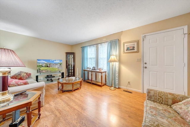 1921 Clinton Ave SE, Roanoke, VA 24013 - living room with light wood-type flooring, a textured ceiling, and baseboards