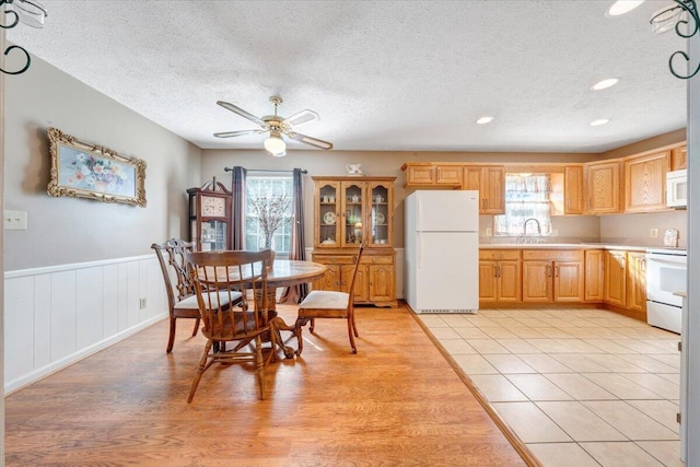 1921 Clinton Ave SE, Roanoke, VA 24013 - kitchen with white appliances, healthy amount of natural light, light countertops, a textured ceiling, and a ceiling fan