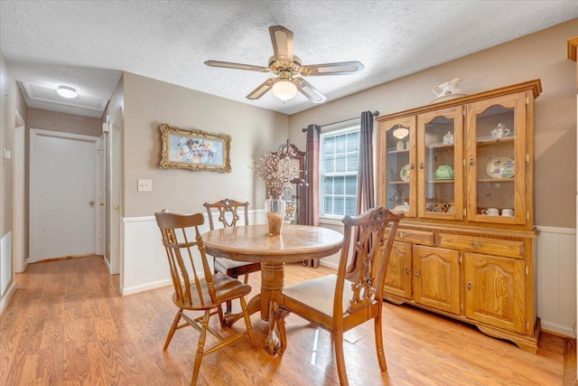 1921 Clinton Ave SE, Roanoke, VA 24013 - dining area featuring a textured ceiling, light wood-type flooring, wainscoting, a ceiling fan, and a decorative wall