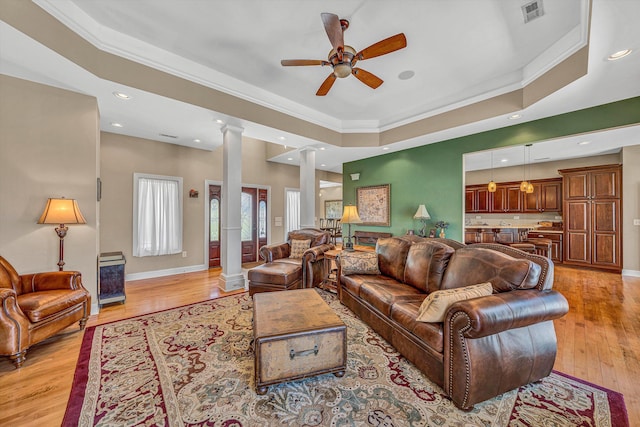 73 Windmere Trl, Moneta, VA 24121 - living room with decorative columns, a ceiling fan, ornamental molding, light wood finished floors, and a tray ceiling