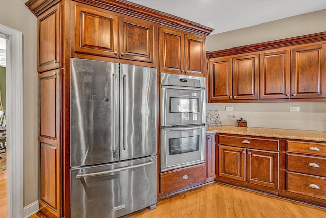 73 Windmere Trl, Moneta, VA 24121 - kitchen with stainless steel appliances, light wood-style flooring, light stone countertops, and brown cabinets