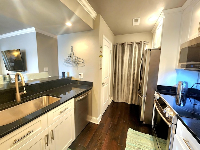 kitchen with stainless steel appliances, a sink, dark wood finished floors, white cabinets, and baseboards