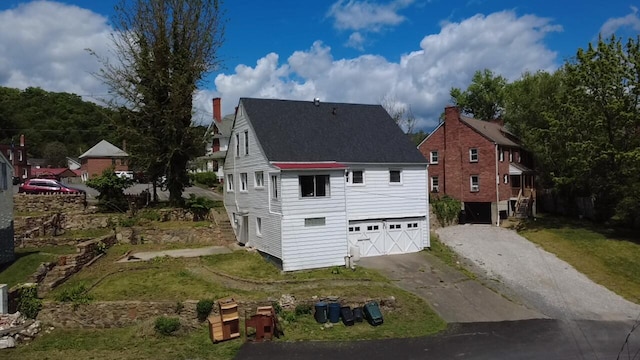 111 Rosedale Ave, Covington, VA 24426 - view of side of home with driveway, a shingled roof, a garage, and a lawn