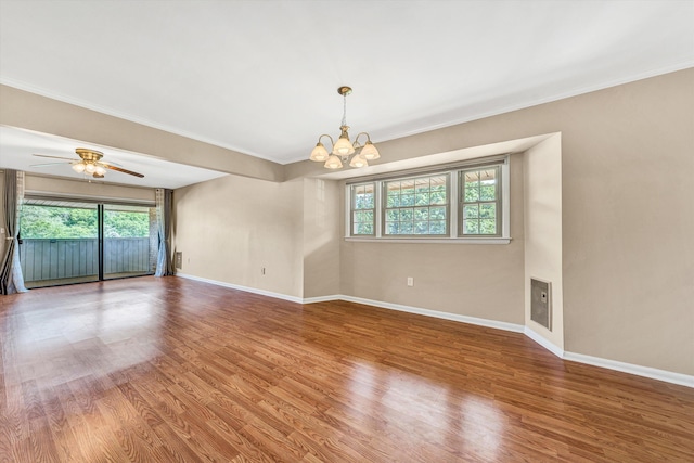 spare room with plenty of natural light, a chandelier, baseboards, wood finished floors, and crown molding