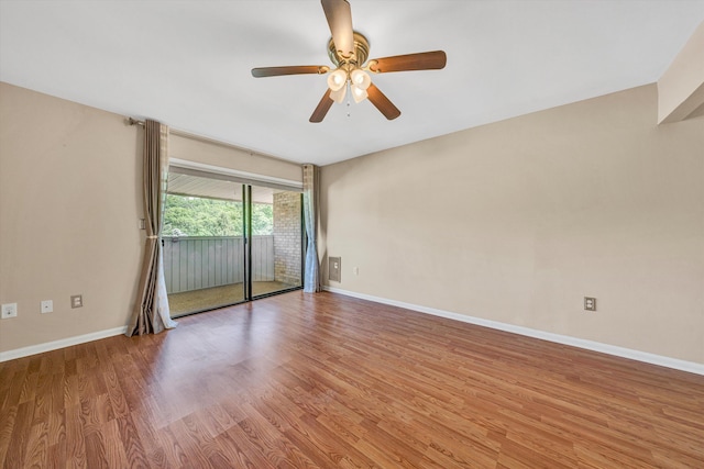 unfurnished room featuring wood finished floors, a ceiling fan, and baseboards