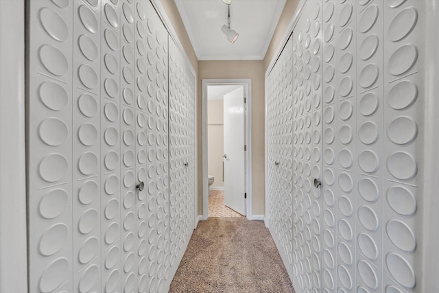 hallway featuring carpet, ornamental molding, and baseboards