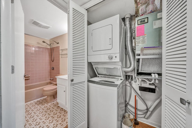 laundry area featuring stacked washing machine and dryer and light flooring