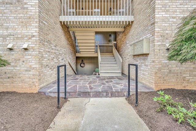 entrance to property with a balcony and brick siding