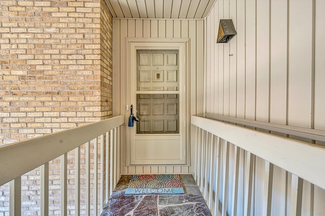 property entrance featuring brick siding and board and batten siding