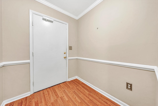 entryway with ornamental molding, light wood-style flooring, and baseboards