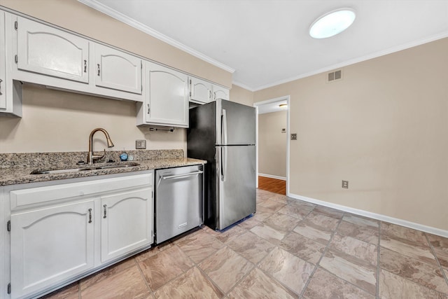 kitchen featuring appliances with stainless steel finishes, a sink, ornamental molding, baseboards, and light stone countertops