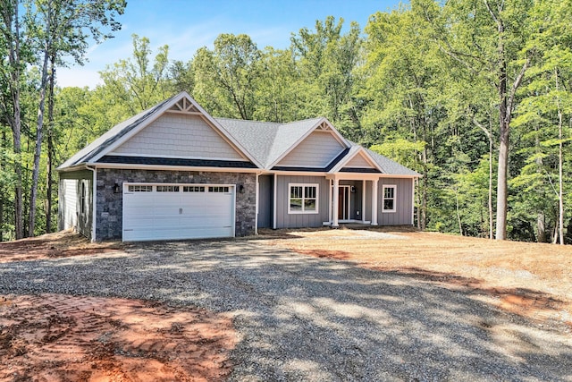 342 Morgans Mill Dr, Penhook, VA 24137 - craftsman-style house featuring gravel driveway, an attached garage, board and batten siding, a view of trees, and stone siding