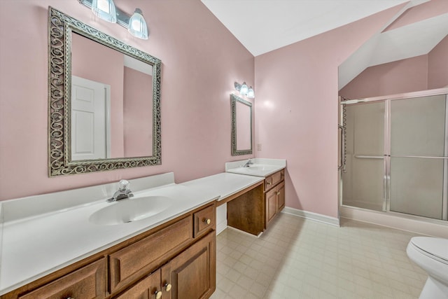 bathroom featuring a stall shower, vanity, baseboards, and toilet