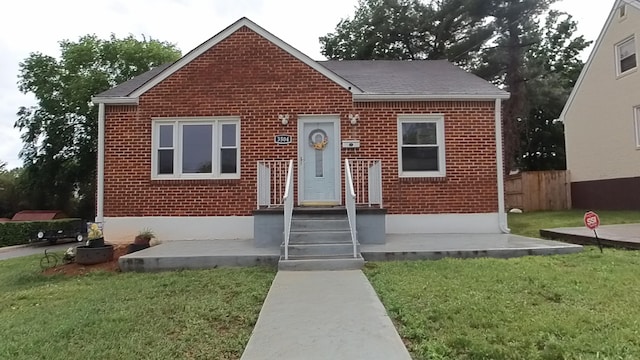 bungalow featuring brick siding and roof with shingles