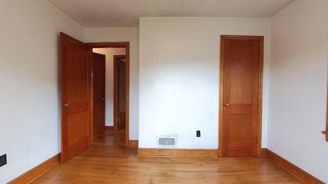 unfurnished room featuring light wood finished floors and baseboards