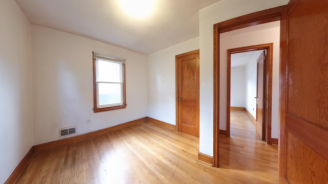 empty room featuring light wood finished floors and baseboards