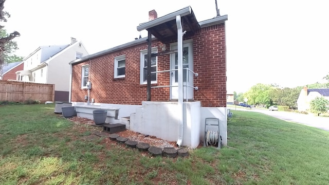 view of side of home with brick siding and a chimney