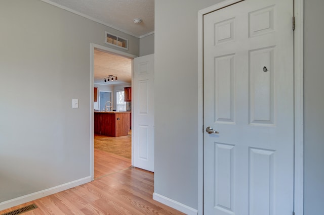 1944 Dickerson Mill Rd, Bedford, VA 24523 - hall with light wood-style floors, baseboards, a textured ceiling, a sink, and crown molding
