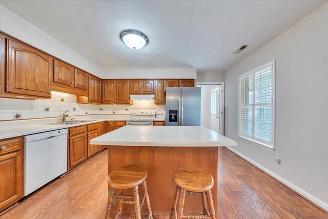 2420 Carlsbad Cir, Roanoke, VA 24012 - kitchen with white appliances, under cabinet range hood, a sink, and light wood-style flooring