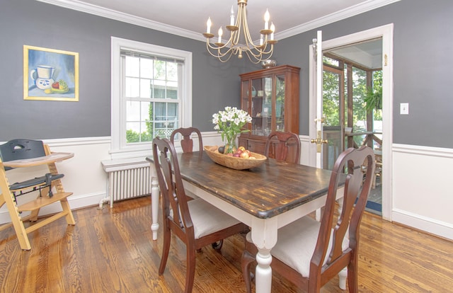 dining space with a chandelier, radiator heating unit, wainscoting, wood finished floors, and ornamental molding
