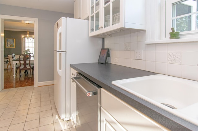 kitchen featuring dishwasher, dark countertops, glass insert cabinets, a chandelier, and white cabinetry