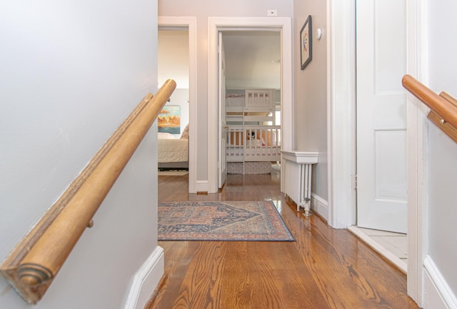 hallway featuring wood finished floors and baseboards